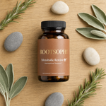 A bottle of ROOTSOPHY Metabolic Rewire+ dietary supplement capsules, styled in a flat-lay on a light wood background with sage leaves, rosemary sprigs, and smooth stones.